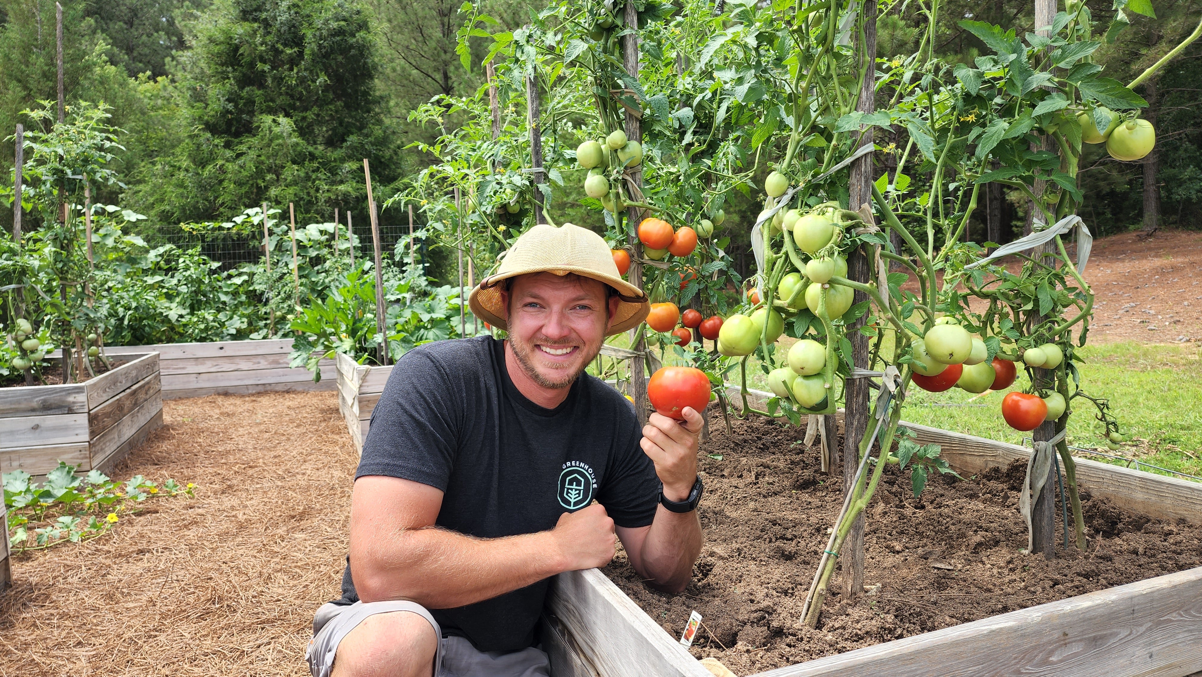 The Story of Gro-Rite Garden - Justin with tomatoes in wooden beds